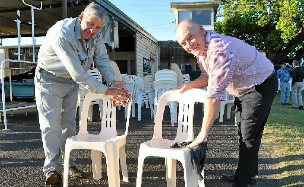 Peter Fraser and Bevan Henningsen help clean the chairs for the Warwick Cup meeting this Saturday. 